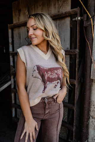 Woman wearing a sleeveless top with a bull graphic in an industrial setting