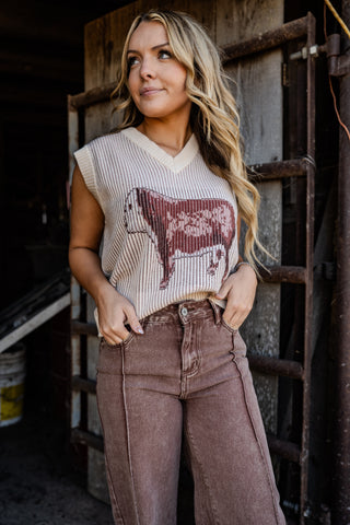 Woman wearing a sleeveless top with a graphic design in a rustic setting