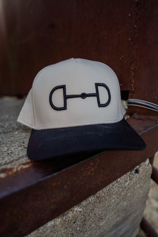 White and black cap with a logo on a wooden surface