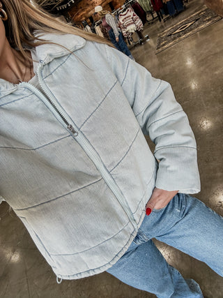 Person wearing a light blue denim jacket in a store setting