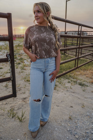 Woman standing in a rural setting with sunset in the background