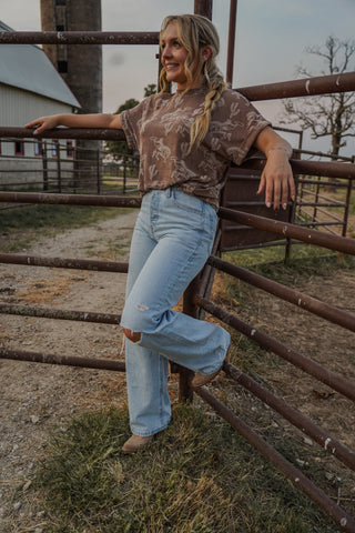 Woman standing by a metal fence in an outdoor setting