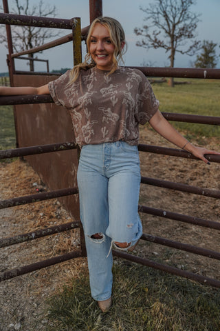 Woman standing behind a metal fence in an outdoor setting