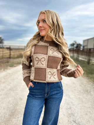 Woman wearing a patterned sweater and jeans outdoors