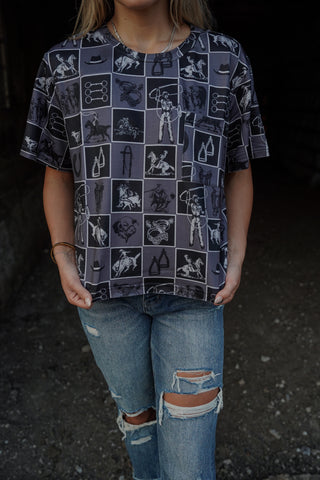 Person wearing a patterned shirt and ripped jeans on a dark background