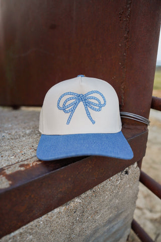 Cap with blue bow design on a metal surface