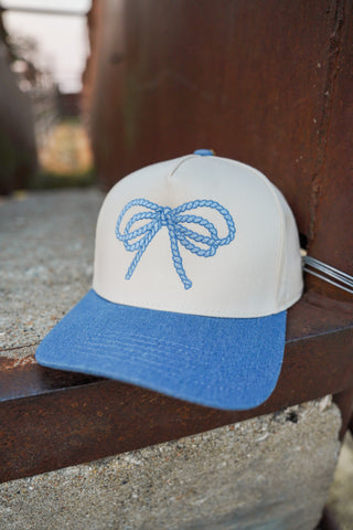 Cap with blue bow design on a metal surface