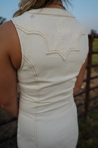 Beige sleeveless dress with intricate stitching detail, worn by a person outdoors.