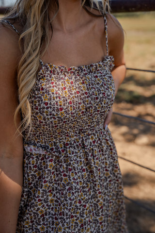 Woman wearing a floral dress with a blurred natural background