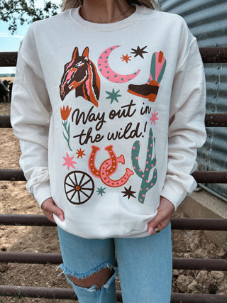 Person wearing a white sweatshirt with cowboy-themed graphics and text in an outdoor setting.