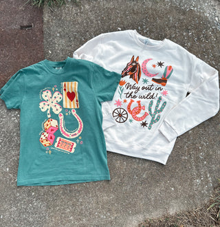 Teal t-shirt and white sweatshirt with colorful graphics on a concrete surface
