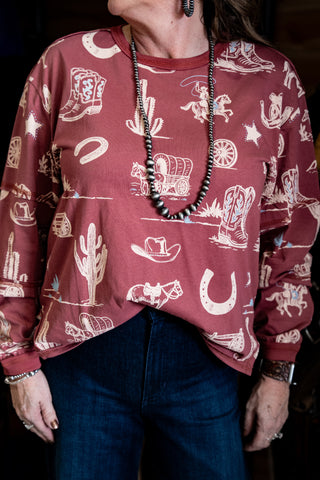 Person wearing a maroon sweatshirt with western-themed patterns