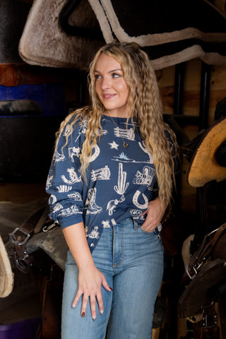 Woman wearing a navy blue shirt with white patterns in a rustic setting
