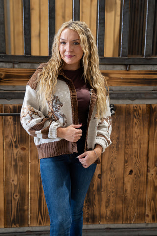 Woman wearing a patterned cardigan in front of wooden panels