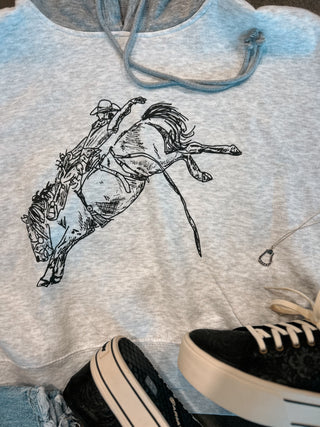 Gray hoodie with a graphic of a person riding a horse, paired with black and white sneakers.