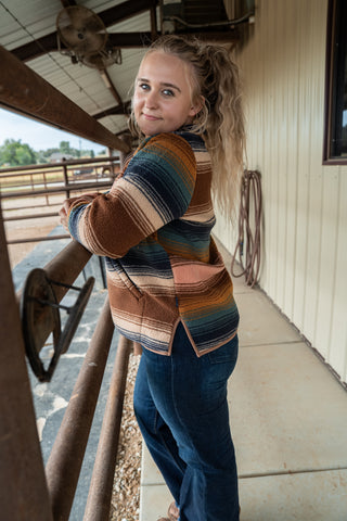 Woman wearing a colorful patterned jacket on a porch