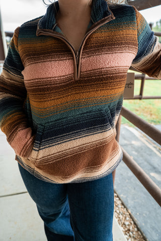 Person wearing a striped sweater with a blurred background