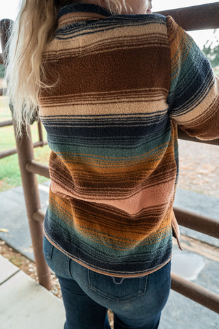 Person wearing a striped sweater with a blurred background