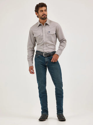 Man wearing a gray button-up shirt and blue jeans on a white background
