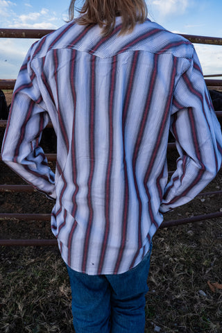 Person wearing a striped shirt with a blurred background