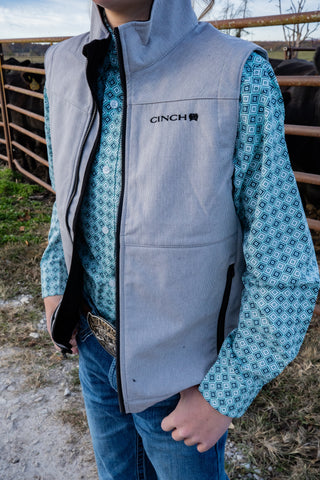 Person wearing a Cinch branded gray vest outdoors.